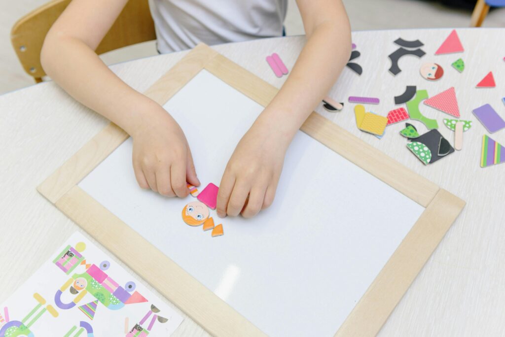 A girl is using different shapes to create everyday object